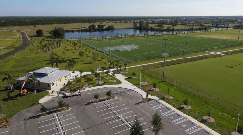 Aerial photo of Festival Park, showing a parking lot, open fields, trees, and water.
